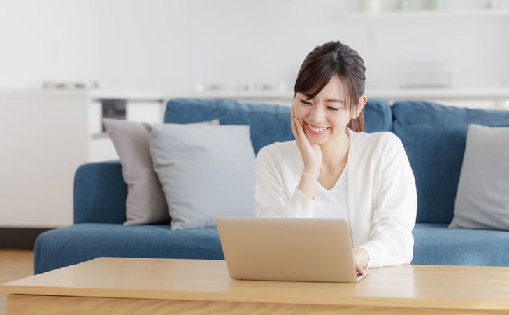 笑顔でノートパソコンを操作する若い女性
