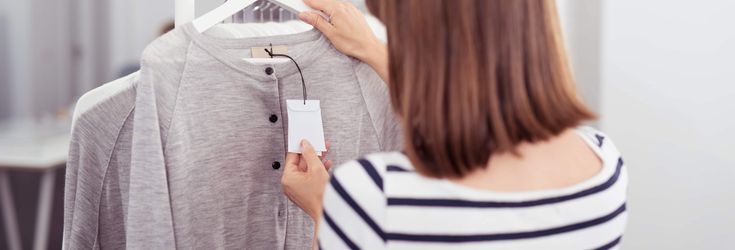 服の値札を確認する女性
