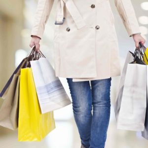 デパートでたくさんの買い物袋を手に歩く女性