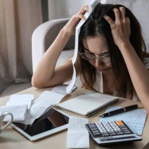 ノートを見つめて頭を抱える女性