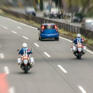 白バイに追いかけられる乗用車